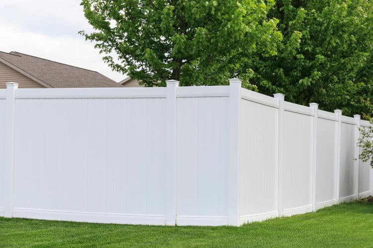 Contemporary white vinyl fence surrounding yard